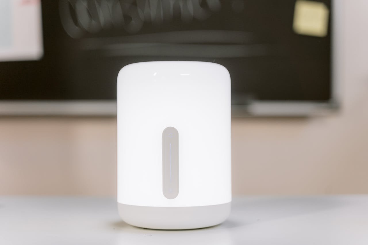 Close-up of a modern white LED lamp on a desk indoors, providing ambient lighting.